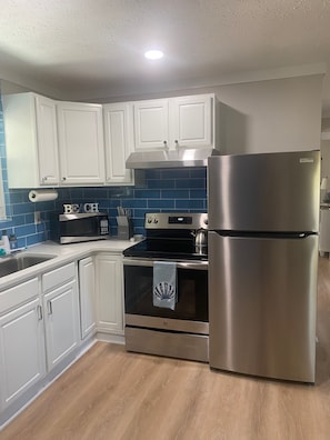 Updated kitchen features quartz countertops and stainless steel appliances.