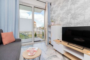 Comfortable living room with a sofa bed, TV and exit to garden.