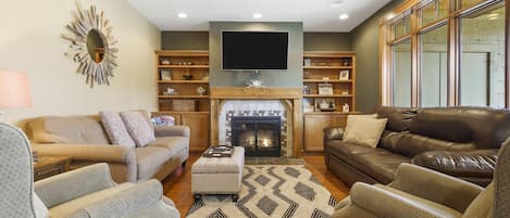 Open living space with sofa sleeper, TV, and fireplace