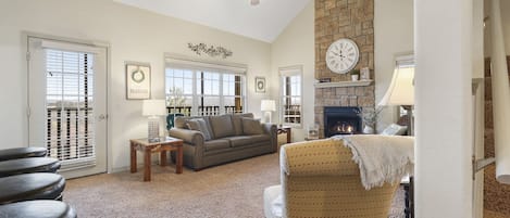 Open living space with, sofa sleeper, Smart TV, fireplace, and screened deck access