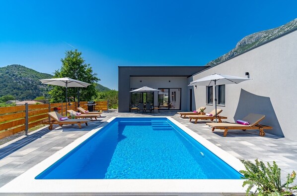 Private swimming pool with 6 deck chairs, outdoor dinning area with BBQ