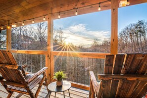 Upper level deck has al fresco dining, nestled in the trees with long range mountain views.