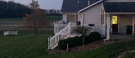 View of deck with table/chairs, small electric grill and single vehicle carport