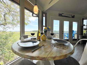 Dining table for four nestled in the trees above the marsh.
