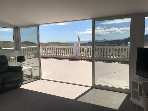 Large patio doors open out onto a large sun terrace with fantastic views