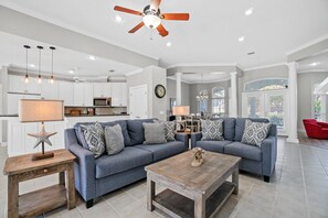 Open concept living room and kitchen with sofa and loveseat. 