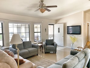 Comfortable living room with recliner, plenty of seating, desk, TV with Streaming apps, and more