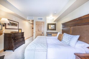 This primary bedroom also offers a mini fridge, breakfast bar, walk in closet, and large dresser with plenty of storage
