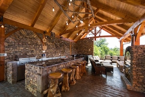 Outdoor pavilion with grill, pizza oven, firepit, hot tub, and m