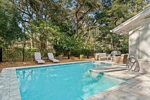 Pool with paved patio and fenced in yard
