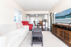 This upstairs apartment includes a small living area for unwinding after a day in the sun, with dining and kitchen area beyond.