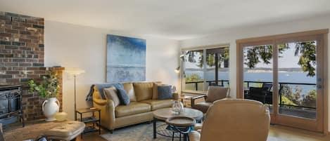 Living room with a wide door and short ramp (ADA)  to an extra large, heated deck with panoramic views of the Saratoga Passage. 