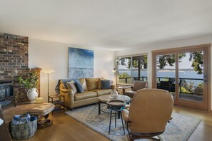 Living room with a wide door and short ramp (ADA)  to an extra large, heated deck with panoramic views of the Saratoga Passage. 