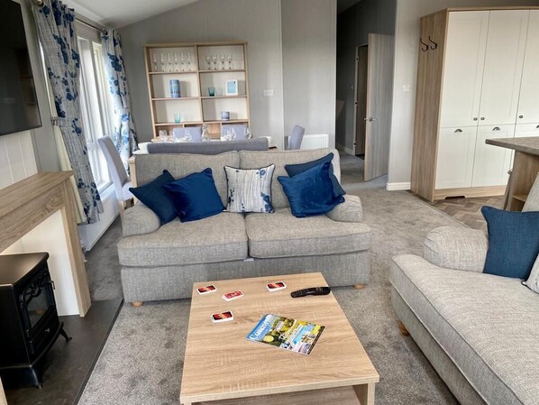 Spacious living area with mock log burner and Smart TV. 