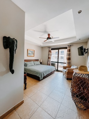 Spacious master bedroom offers seating, balcony, and Smart TV