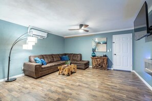Comfortable seating with an electric fireplace and large TV.