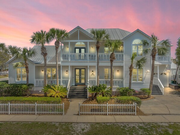 This stately beachside home features new amenities, beautiful porches and palms