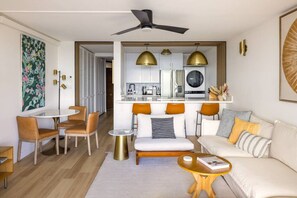 Living room with ample seating and a fully equipped kitchen with luxury appliances. Oversized quartz island with seating for 3. Washer dryer. Dining table with seating for 3 with original local art.