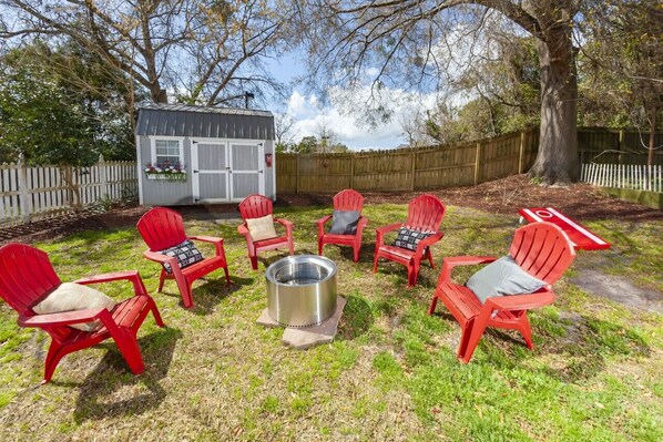 A private spacious backyard has plenty of seating around the fire pit for roasting smores.