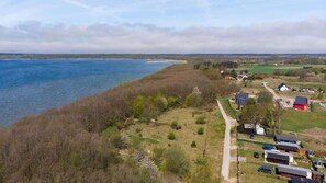  A stunning aerial view of a scenic landscape with hills, trees, and nearby housing.