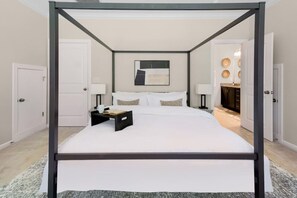 The primary suite is drenched in light and features an ultra comfortable king bed, a large TV, a reading nook, a desk, an ensuite bathroom, and walk-in closet.