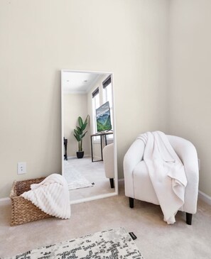 Snuggle up in the reading nook in primary bedroom. You can also see the large TV in the reflection.
