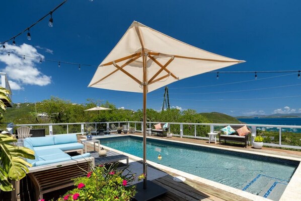 Pool and pool deck with outdoor furniture, sun loungers, and an umbrella in case you want some shade.