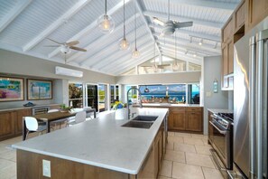 The spacious and well-appointed kitchen with full AC, kitchen island, and bar stools.