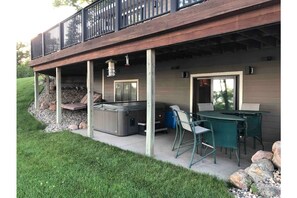 Lower patio with seating and hot tub.