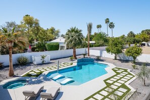 Resort-style backyard with sparkling heated pool & spa, sun loungers, BBQ grill, covered gazebo with multiple lounge areas, outdoor seating, and putting green setup.