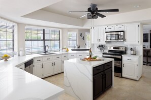 The fully equipped modern kitchen is stocked with all culinary essentials and stainless-steel appliances. (1st Floor)