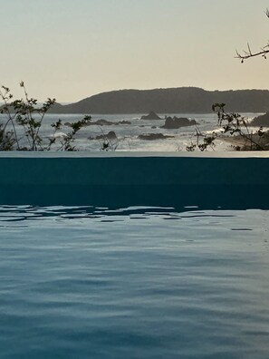 Pool with ocean and sunset views