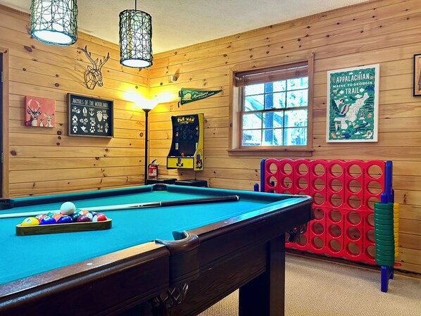Game room with pool table, ROKU TV, PAC-Man, Jumbo Connect Four and board games.