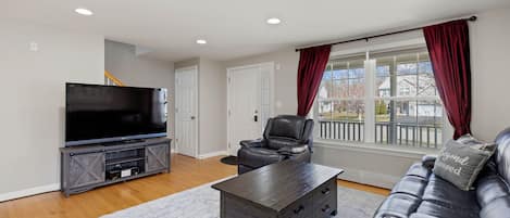 Living room with oversized leather reclining couch, recliner and 60" smart tv