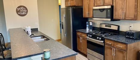 Full kitchen with Keurig, microwave, toaster and dishes/cookware. 