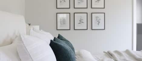 Primary bedroom has a comfortable, upholstered king-sized bed.