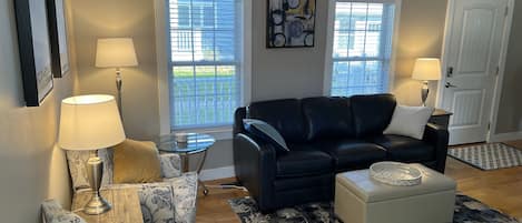 Living room with full-size leather sofa, 2 accent chairs, gas fireplace, and TV.