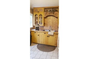 Full Kitchen with stove and refrigerator.  Tablet and 2 chairs under window.