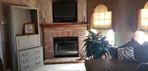 Faux fireplace with T.V. on top and s stand up work station.