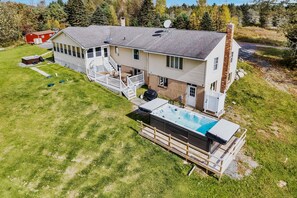 View from back of the house with swim spa, deck and hot tub