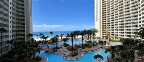 View of epic pool, tiki bar & grill, hot tub, and gulf from balcony