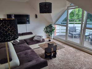 Wohnzimmer mit Elektrokamin und Balkon