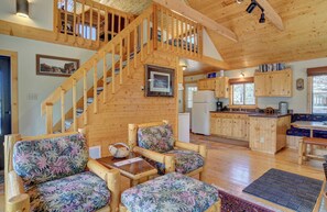 Living room with stairs to loft bedroom. - Our bright and open cabin concept is the perfect mountain getaway for a family or two couples.  Upstairs is an open bedroom with queen bed and sitting area.