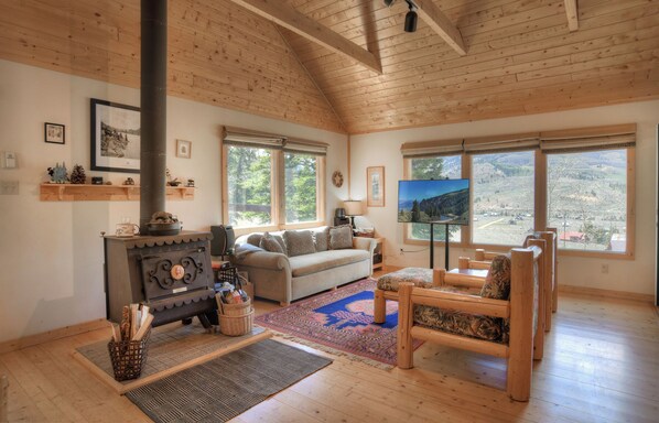 Living room with fireplace and smart TV - Enjoy stunning views of Bristol Head from the large picture windows after a long day of exploring the National Forest.  Our cabin is equipped with a woodburning fireplace.