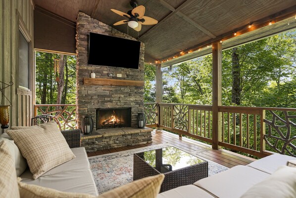 Main level back deck with wood burning fireplace and big screen smart tv