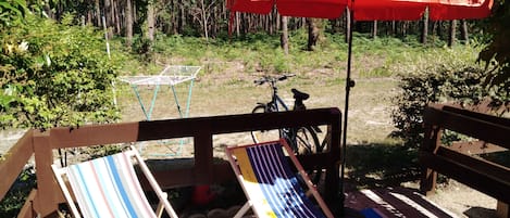 2 chiliennes, un tapis et un parasol avec vue sur la forêt landaise