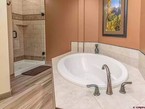 Master bath with full-size bathtub and shower. 