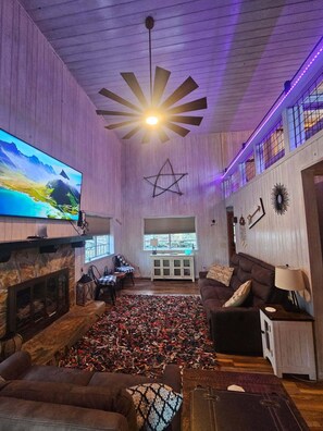 Open-concept living area with cozy seating, a fireplace, and river views.