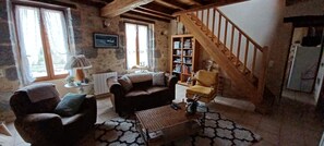 salon avec canapé non convertible et fauteuils  l'escalier donne dans la chambre