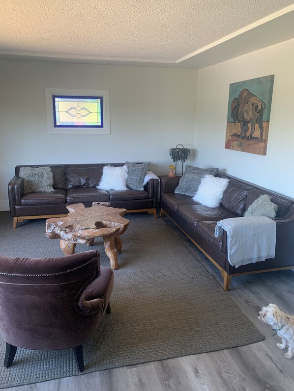 Main living area w/ seating to face the panoramic windows offering mountain view